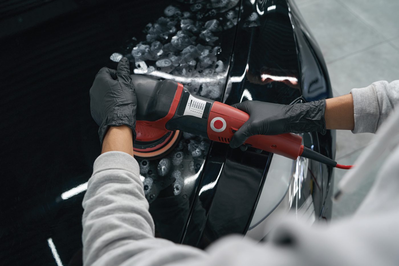 a TintBusiness cleaning a vehicle from a front view